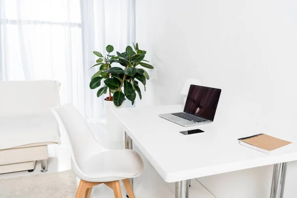 Portátil con pantalla en blanco, portátil, teléfono inteligente en la mesa en la oficina en casa — Stock Photo