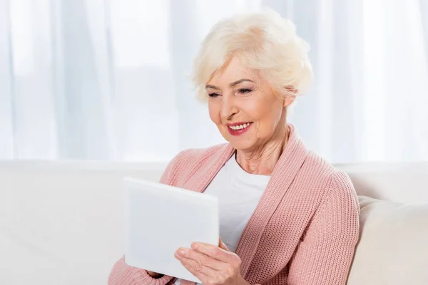 Ritratto di donna anziana allegra utilizzando tablet digitale a casa — Foto stock