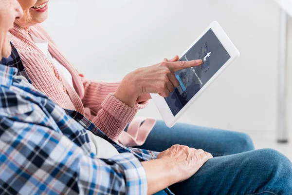 Plan recadré d'un homme et d'une femme âgés souriants utilisant une tablette numérique avec le logo tumblr à l'écran ensemble — Photo de stock