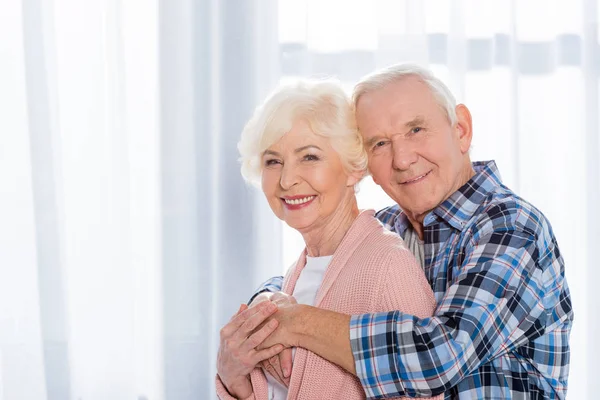 Porträt eines glücklichen Senioren-Paares, das in die Kamera blickt — Stockfoto