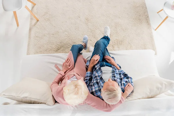 Счастливая старшая пара сидит на уютном диване вместе — стоковое фото