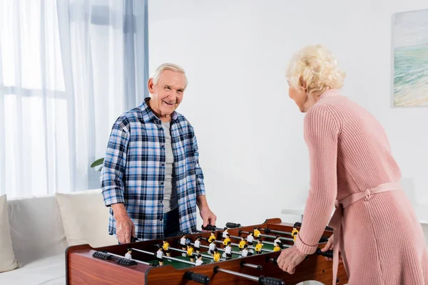 Happy senior couple playing table football — Stock Photo