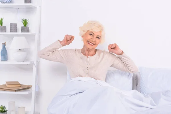 Porträt einer fröhlichen Seniorin, die zu Hause im Bett liegt — Stockfoto