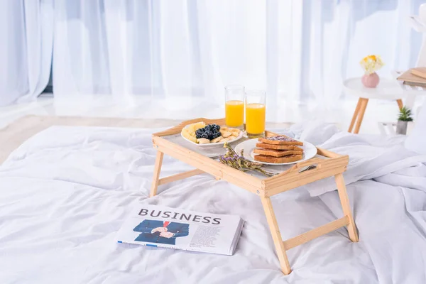 Café da manhã saudável na cama na bandeja de madeira pela manhã — Fotografia de Stock