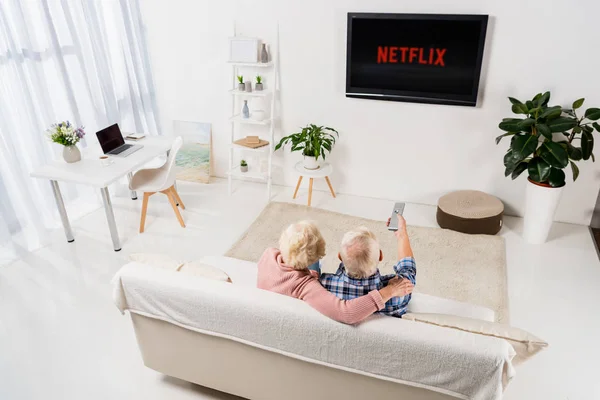 Pareja de ancianos viendo netflix en la televisión en casa - foto de stock