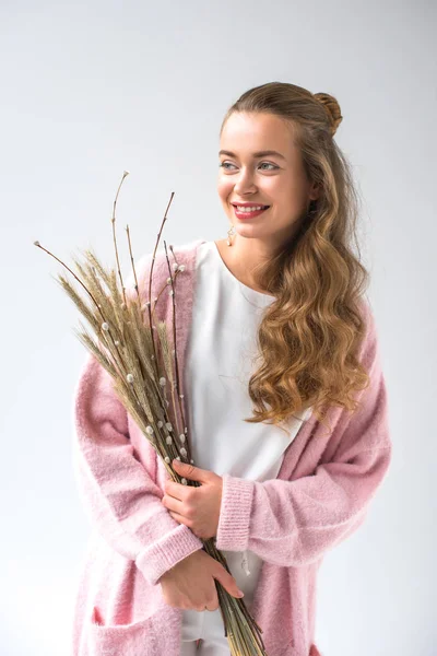 Smiling woman holding bunch of willow tree branches and spikelets isolated on white — Stock Photo