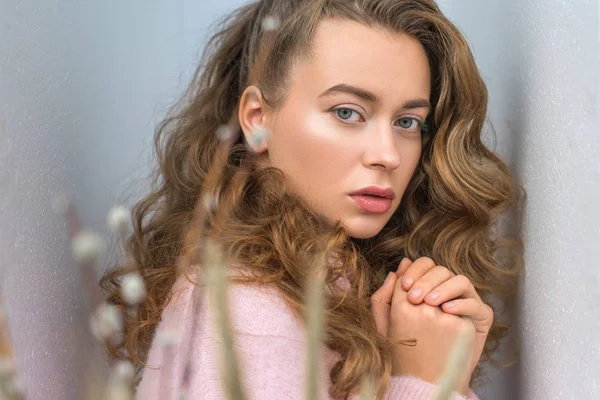 Beautiful girl standing between gray walls and looking at camera — Stock Photo