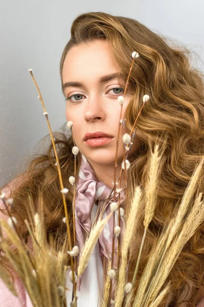 Retrato de mujer con pelo rizado con ramas de sauce y espiguillas en primer plano — Stock Photo