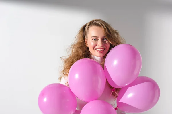 Schönes lächelndes Mädchen mit einem Bündel rosa Luftballons — Stockfoto