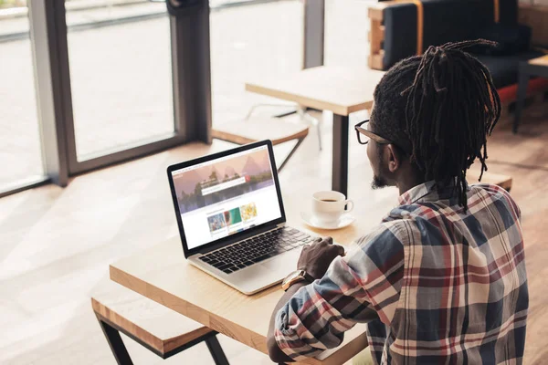 Afrikanisch-amerikanischer Mann benutzt Laptop mit Shutterstock-Website im Café — Stockfoto