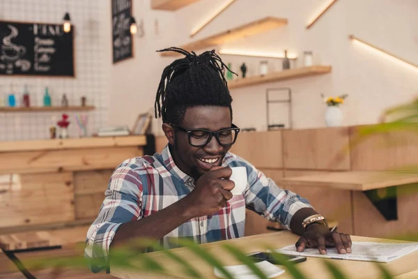 Homme afro-américain joyeux boire du café aromatique dans le café — Photo de stock