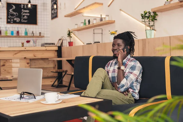 African american man talking on smartphone in coffee shop — Stock Photo