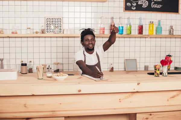 African american barista gesturing and taking order at bar counter — Stock Photo