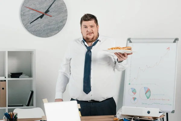 Gros homme d'affaires avec la malbouffe au bureau — Photo de stock