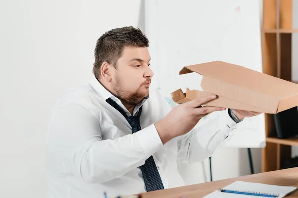 Overweight businessman eating pizza at workplace — Stock Photo