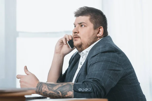 Gordo hombre de negocios hablando en el teléfono inteligente en la oficina - foto de stock