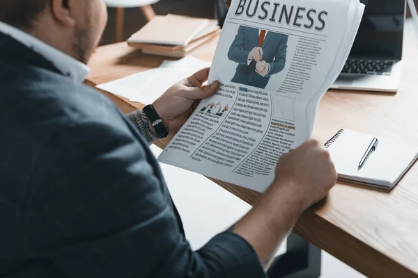 Abgeschnittene Ansicht eines übergewichtigen Geschäftsmannes, der am Arbeitsplatz Wirtschaftszeitung liest — Stockfoto