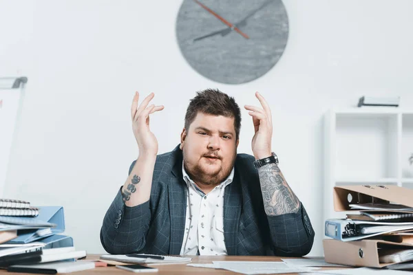 Tired overweight businessman in suit doing paperwork in office — Stock Photo