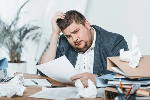 Fat businessman in suit doing paperwork in office — Stock Photo