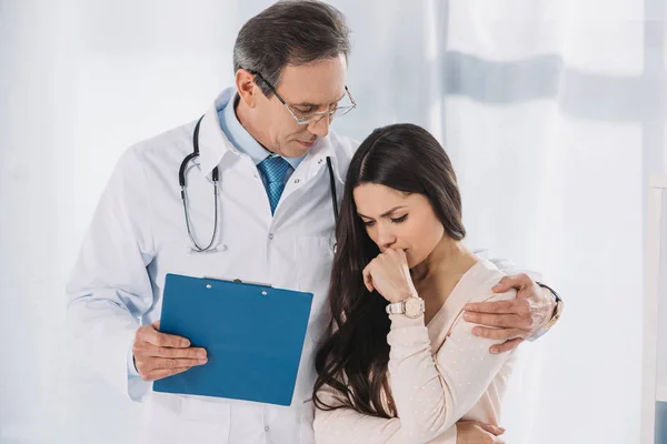 Masculino médico abraçando chateado paciente feminino — Fotografia de Stock