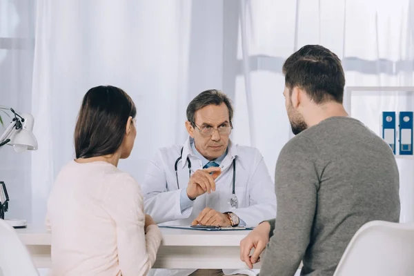 Wife and husband listening doctor at clinic — Stock Photo