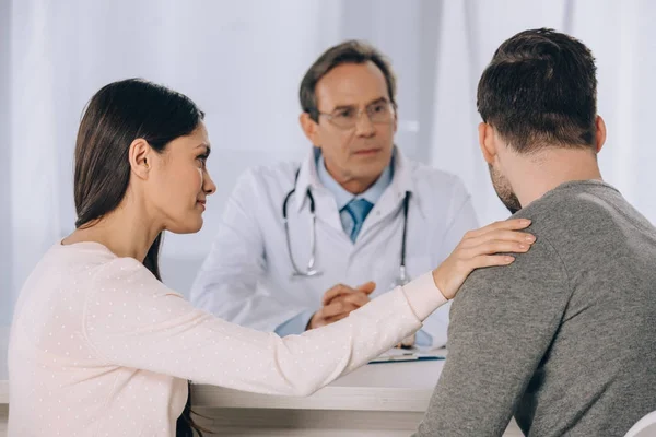 Girlfriend hugging and supporting boyfriend at clinic — Stock Photo