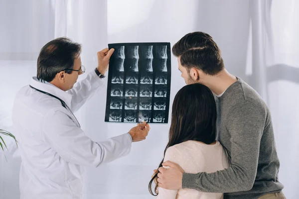 Doctor showing couple x-ray photo — Stock Photo