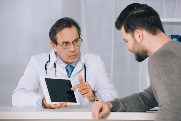 Médico mostrando algo ao paciente em comprimido — Fotografia de Stock