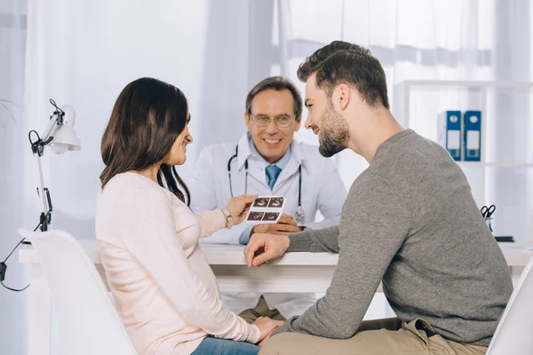 Esposa y marido mirando la foto de diagnóstico por ultrasonido - foto de stock