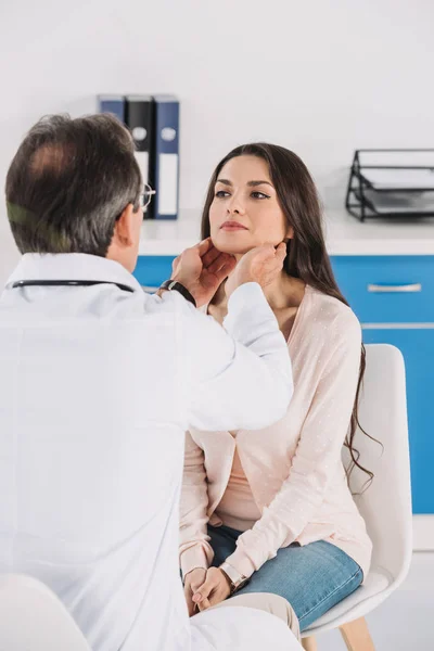 Male doctor palpating female patient lymph nodes — Stock Photo