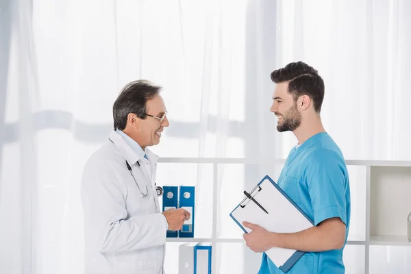 Medico sorridente che parla con l'infermiera alla clinica — Foto stock