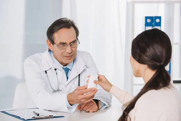 Médico masculino dando píldoras a paciente femenino - foto de stock