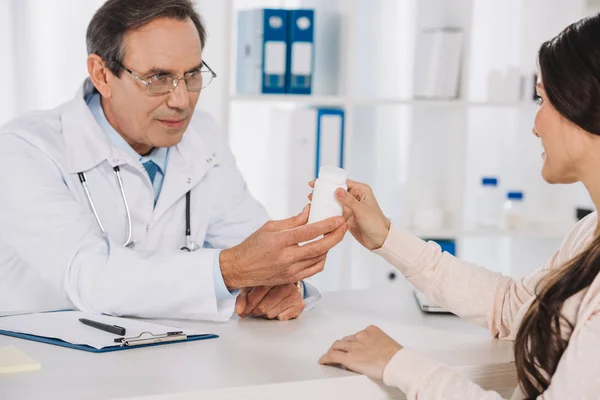 Médico dando pílulas para paciente do sexo feminino — Fotografia de Stock