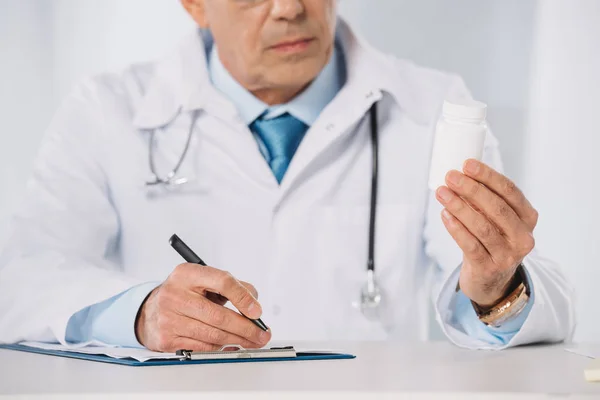 Обрізане зображення лікаря, який дивиться на таблетки — стокове фото