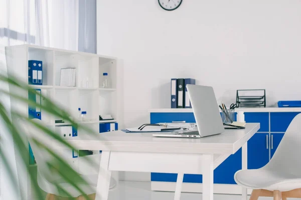 Lugar de trabajo con portátil en la mesa en la clínica - foto de stock