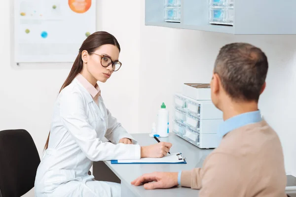 Enfoque selectivo del paciente en la recepción de los médicos en la clínica - foto de stock