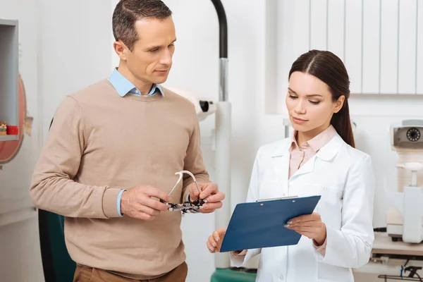 Portrait of patient with trial frame in hands at the oculists reception in clinic — Stock Photo