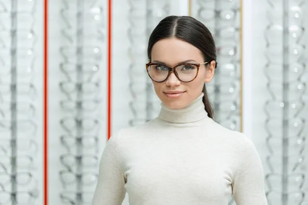 Портрет красивої молодої жінки в окулярах дивиться на камеру в оптиці — стокове фото