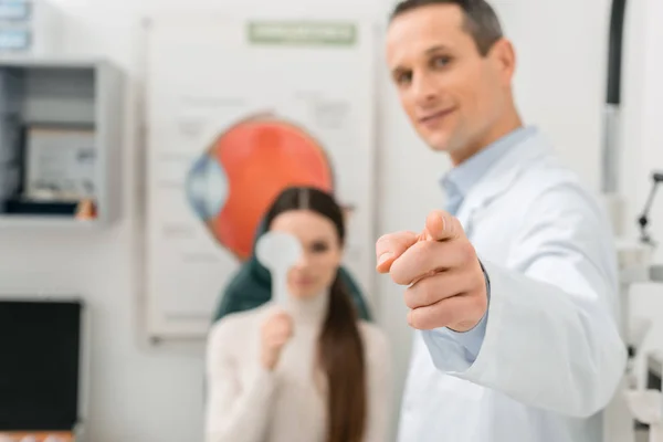 Selective focus of patient getting eye test by oculist in clinic — Stock Photo