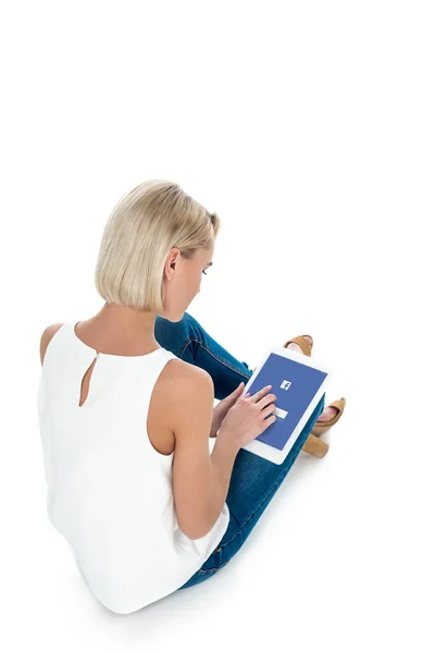 Back view of blonde woman using digital tablet with facebook app, isolated on white — Stock Photo