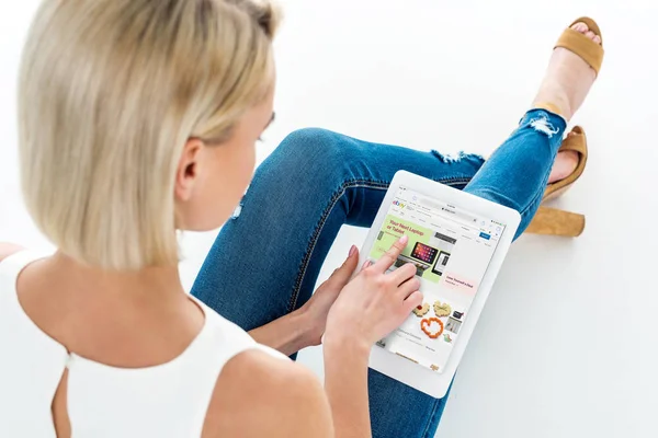 Back view of blonde woman using digital tablet with ebay app, isolated on white — Stock Photo