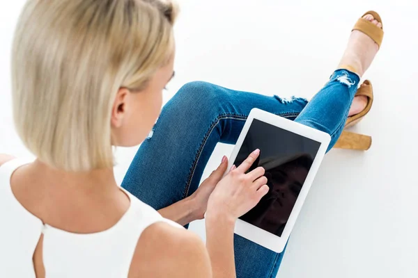 Back view of blonde woman using digital tablet with blank screen, isolated on white — Stock Photo