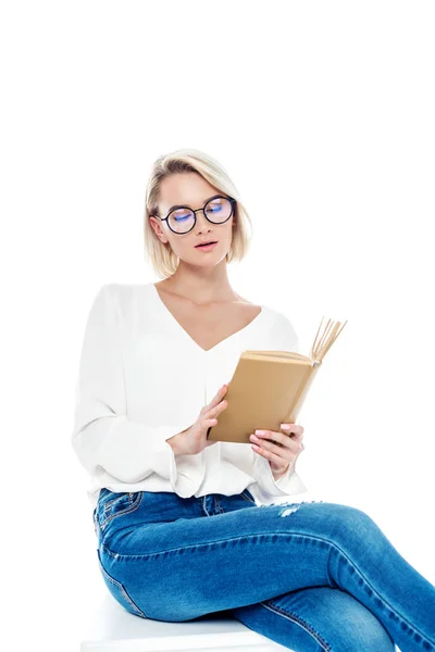 Jolie fille blonde dans des lunettes de lecture livre, isolé sur blanc — Photo de stock