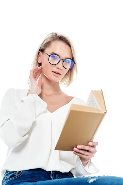Beautiful blonde girl in eyeglasses reading book, isolated on white — Stock Photo