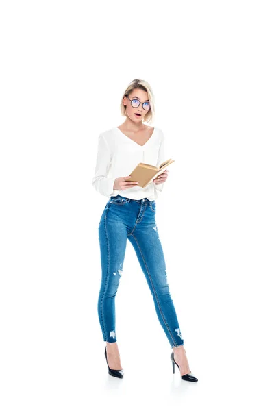 Красива шокована стильна дівчина в окулярах читає книгу, ізольована на білому — стокове фото