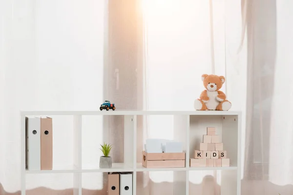 Estante de madeira com pastas organizadas e brinquedos — Fotografia de Stock