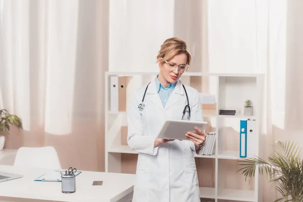 Porträt des Allgemeinmediziners im weißen Kittel am Tisch in der Klinik — Stockfoto