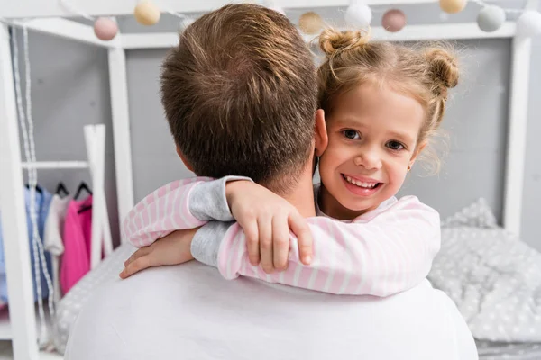 Vista posteriore di adorabile figlioletta abbracciando padre — Foto stock