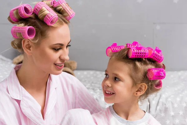 Jovem bela mãe e filha com rolos de cabelo na cabeça — Fotografia de Stock