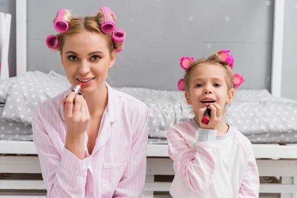 Sorrindo mãe e filha fazendo maquiagem e olhando para a câmera — Fotografia de Stock